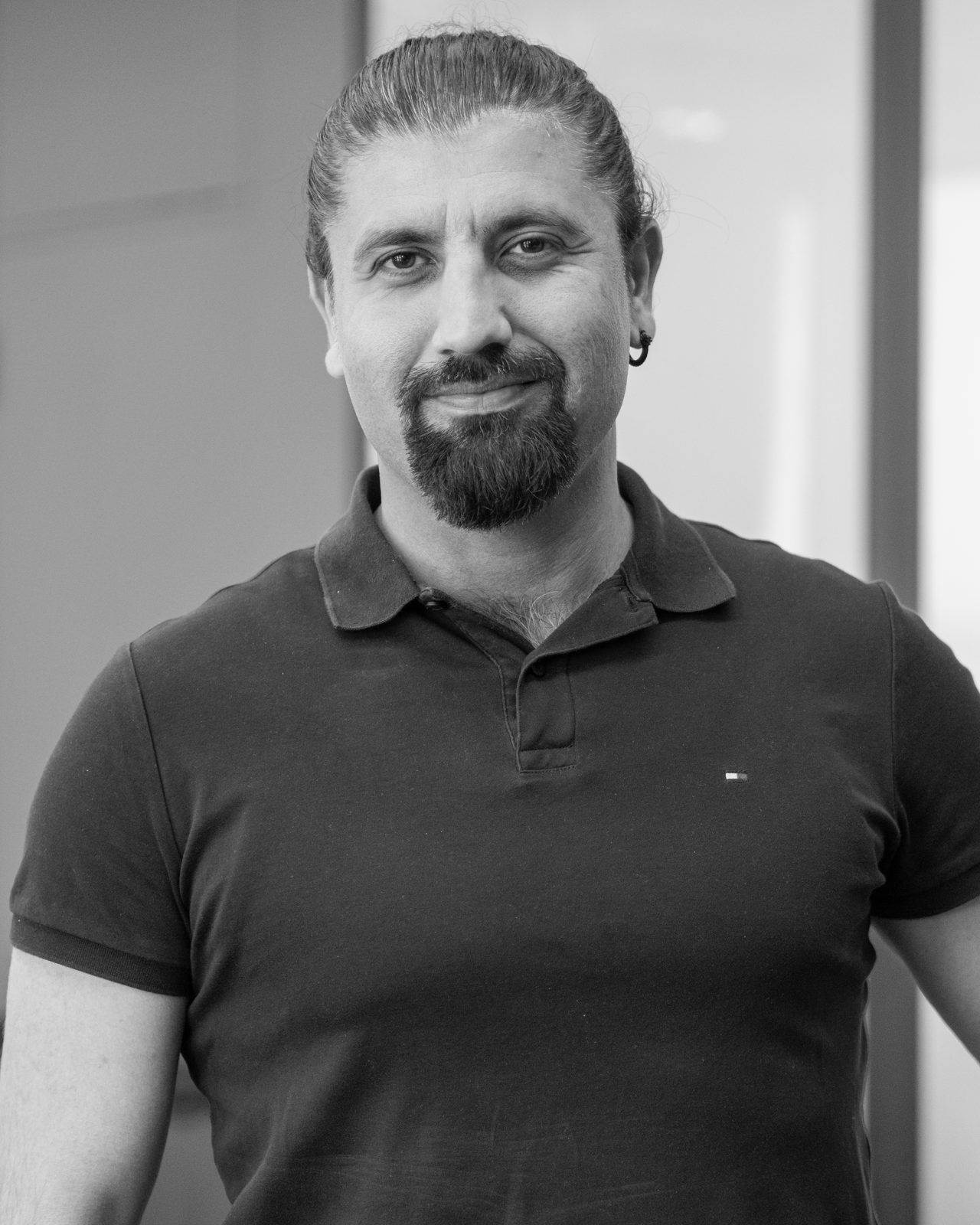 Hüseyin, Managing Director of SAM Innovate, smiling in the office in Munich